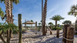 A sandy beach area with palm trees, a hammock, and a wooden structure. - Storey Lake Resort, Private Pool, and Much More!! (Kissimmee)