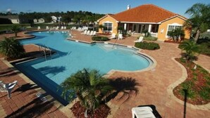A swimming pool with lounge chairs and a building with a red roof. - Gated Community, Private Pool and Game Room Near Disney!!! (Kissimmee)
