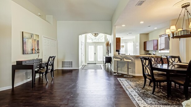 A spacious hallway with a dining area, kitchen, and a view of the living room. - Gated Community, Private Pool and Game Room Near Disney!!! (Kissimmee)