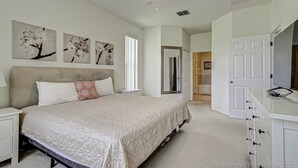 A bedroom with a bed, nightstands, a dresser, and a ceiling fan. - Gated Community, Private Pool and Game Room Near Disney!!! (Kissimmee)