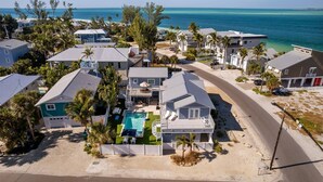 A coastal residential area with houses, a swimming pool, and a beach. - Back To Blue: Amazing Bean Point Location, Resort Style Backyard with Pool by Anna Maria Life (Anna Maria)