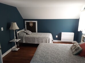 Cozy bedroom with two single beds and a bedside table.