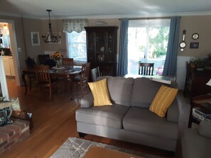 Relax in this inviting living room with a sofa, dining area, and brick fireplace.