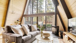 Une chambre à coucher confortable, aménagée en style «
loft
», avec une grande fenêtre, un canapé, une table basse et une cheminée.