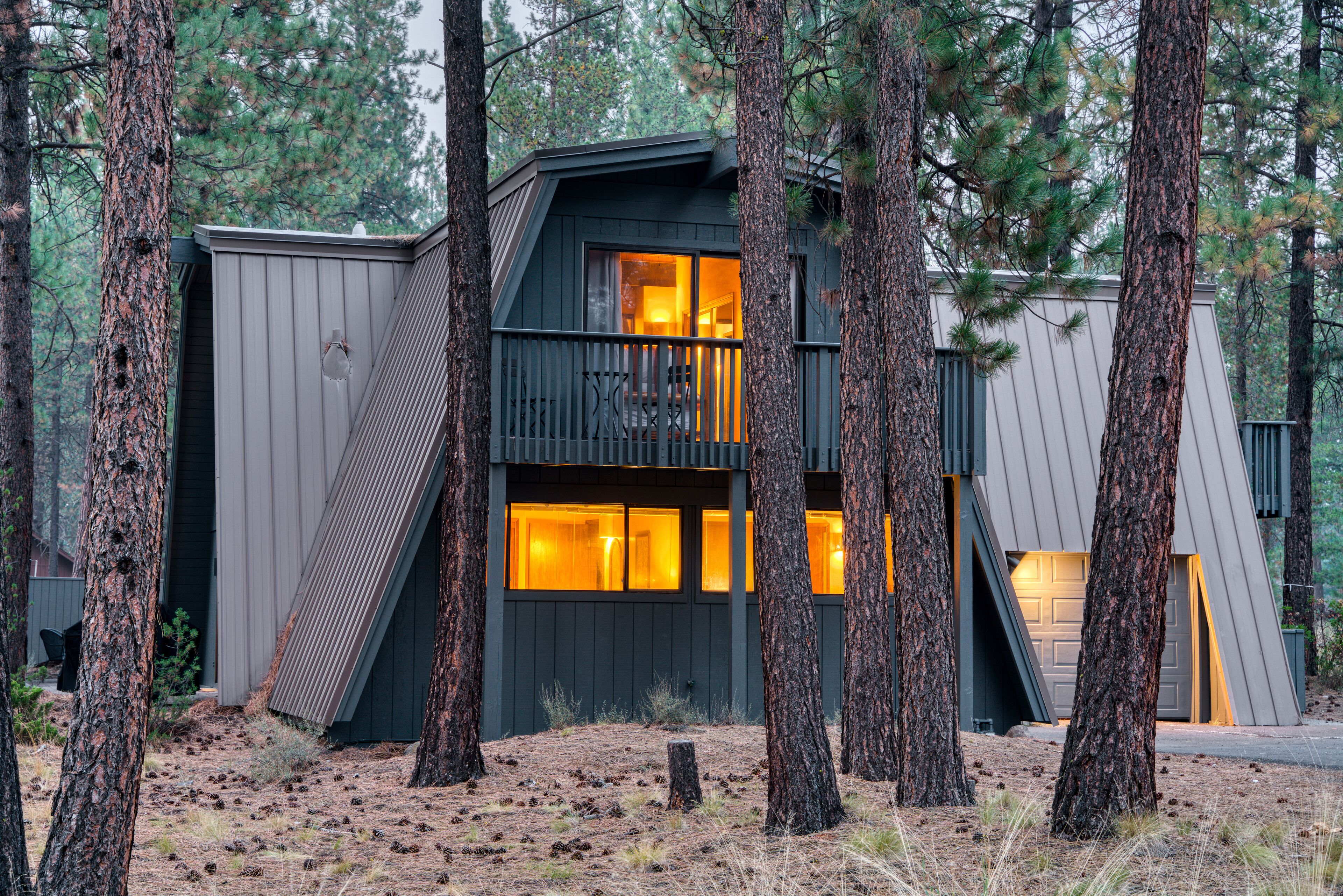 A modern cabin with a sloped roof, large windows, and a balcony.