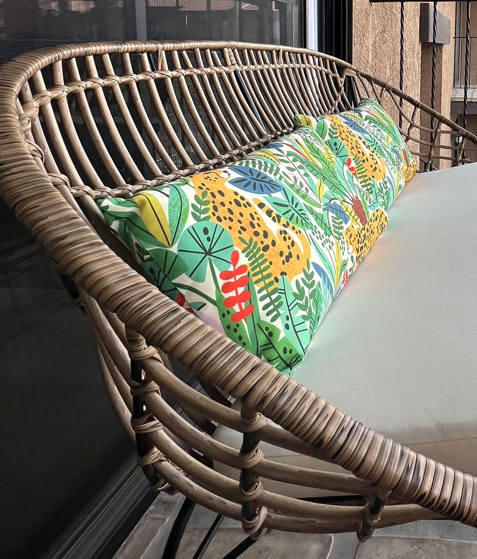 A wicker chair with a colorful cushion.