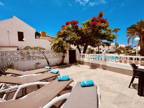A poolside area with lounge chairs and a white fence. - Beach Bungalow Holiday Home (Torviscas Bajo)