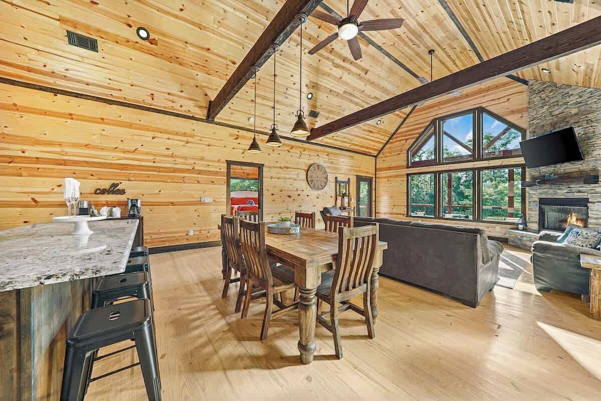 A spacious wooden cabin with a dining area, kitchen, and living space.