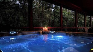 A hot tub area with a view of a forest. - 3 King Suites, Hot Tub, Firepit, Playset, Dogs OK (Broken Bow)
