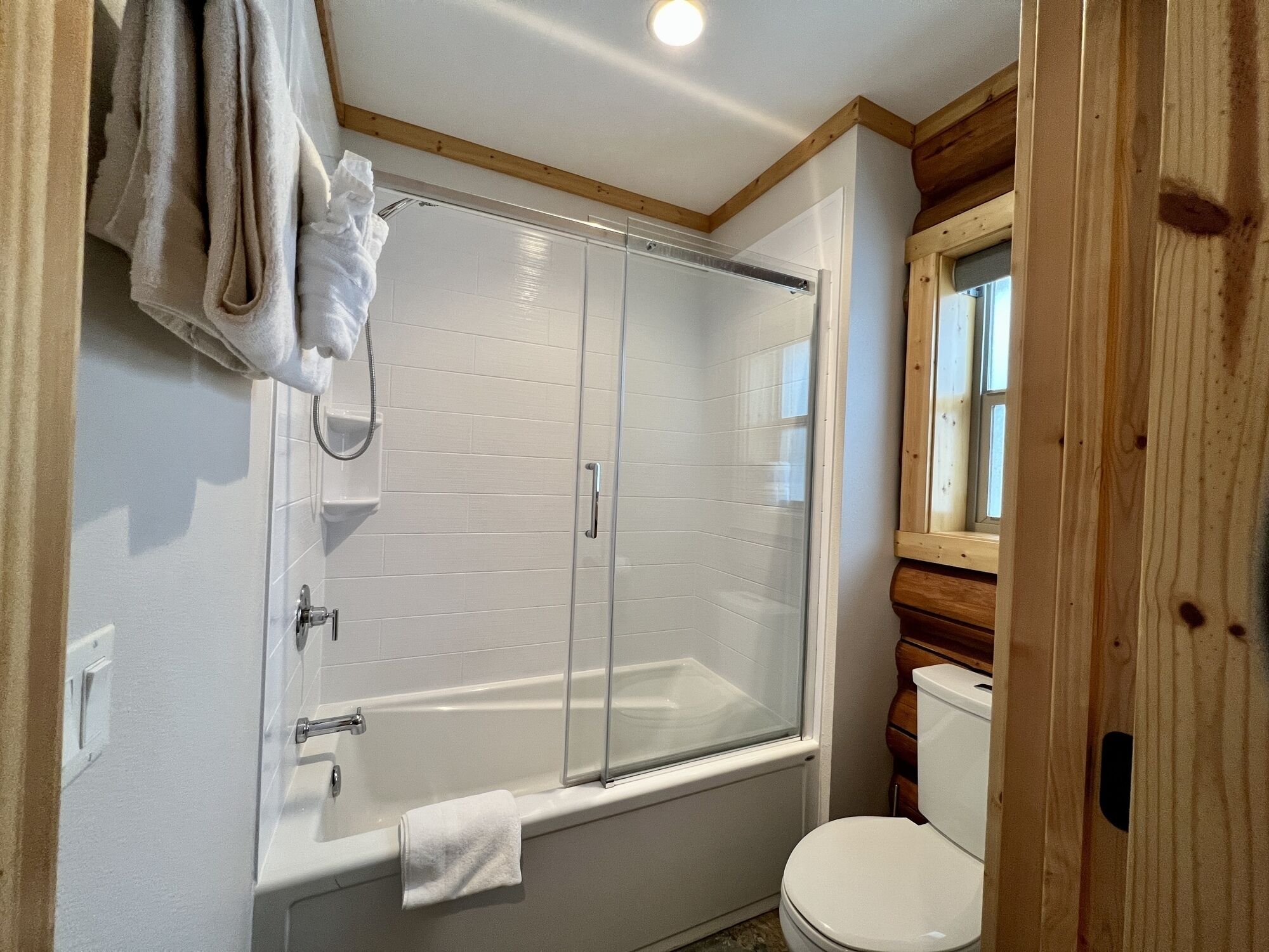 Un baño con ducha de vidrio, una bañera blanca y un inodoro.