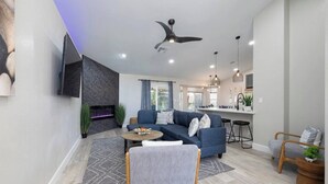 A modern living room with a sofa, coffee table, and a fireplace. - Oasis in the Desert w/ Heated Pool Fully Renovated (North Las Vegas)