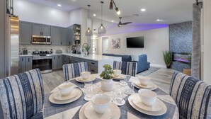 A modern kitchen with grey cabinets, a built-in microwave, and a stainless steel refrigerator. - Oasis in the Desert w/ Heated Pool Fully Renovated (North Las Vegas)