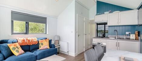 Una sala de estar moderna con un sofá, una mesa de centro y vistas al exterior.