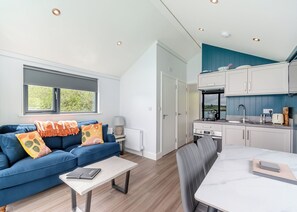 A modern living room with a sofa, coffee table, and a view of the outdoors.