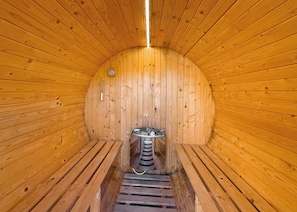 A sauna with wooden walls and a central bench.