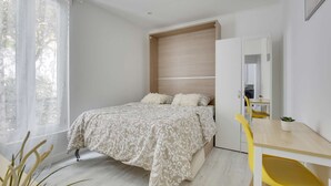A bedroom with a bed, a desk, a chair, and a wardrobe. - Chic studio near Paris (Colombes)