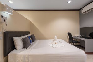A hotel room with a bed, a desk, a chair, a hairdryer, and an air conditioning unit. - Bkk39 Airport hotel (Bang Phli)