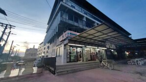 Un bâtiment moderne doté d’une entrée couverte et d’un vélo garé à l’extérieur.