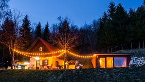 Une cabane dotée d’un coin repas, d’un espace extérieur aménagé et d’un mur en pierre.
