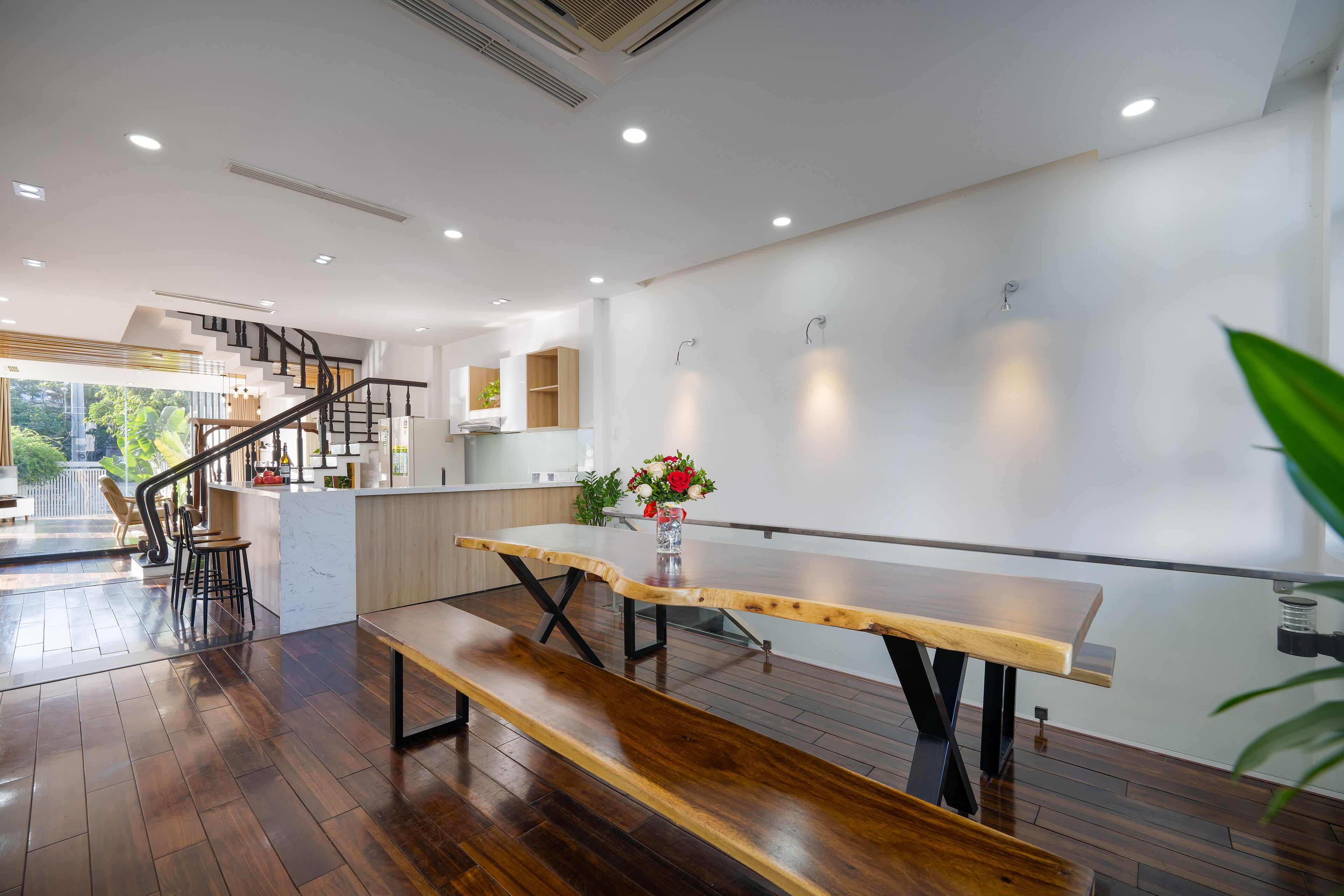 Una cocina moderna con un banco de madera, una escalera y vistas al exterior.