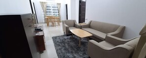 A compact living space with a sofa, a small table, and a dining area with chairs. - Senri By Yuhi (Tada)