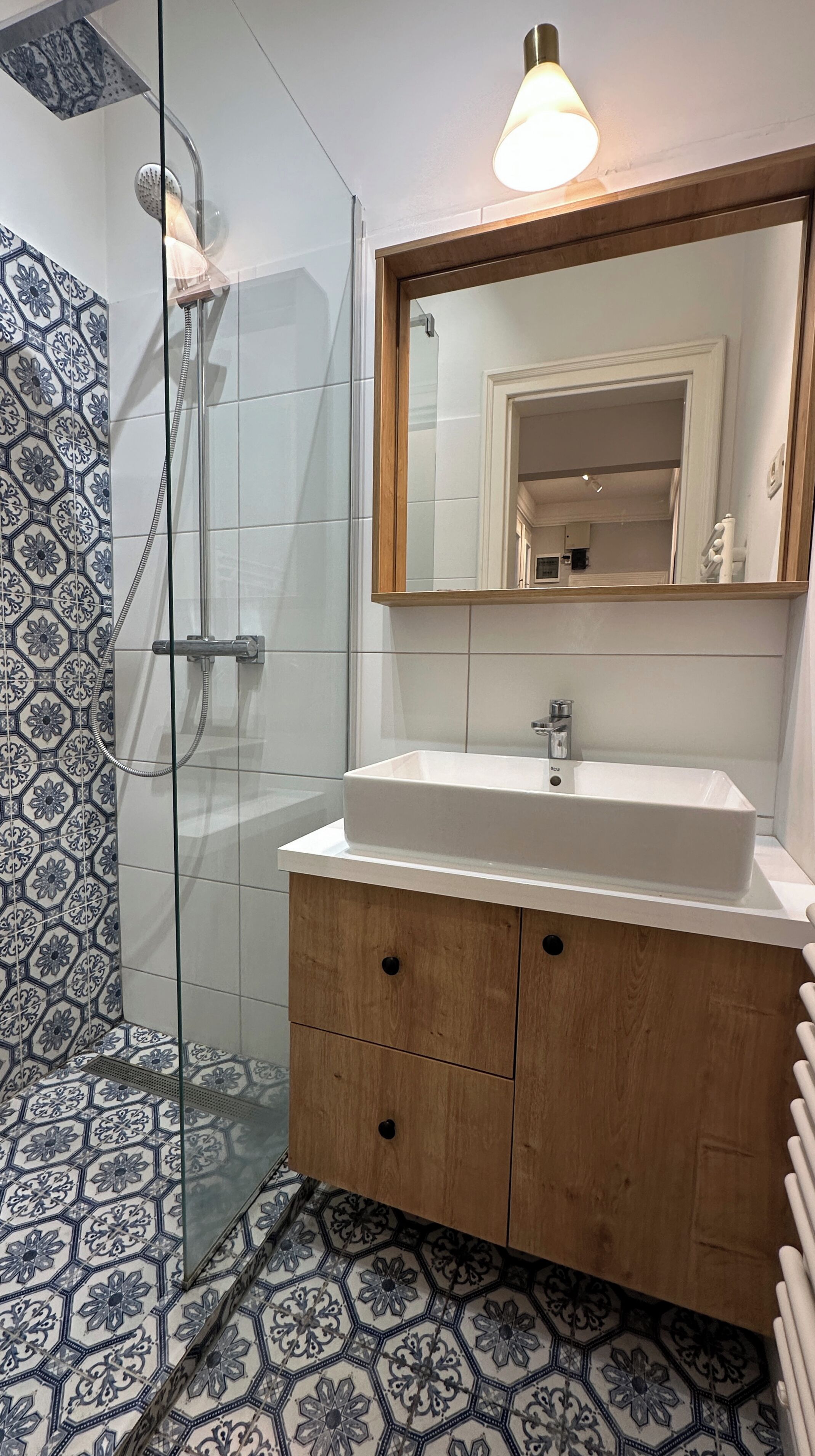 Un baño con ducha, lavamanos y espejo.