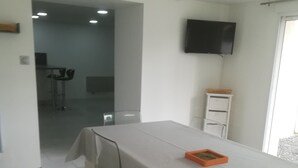 Een vergaderzaal met een lange tafel, stoelen, een televisie aan de muur en een raam.