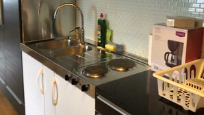 A modern kitchen with black cabinets, stainless steel appliances, and a white countertop. - Årsta Stockholm Aparment 339 (Arsta)
