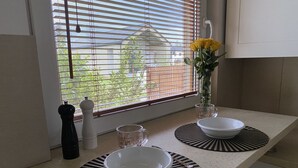 A kitchen counter with two white bowls on black and white patterned placemats, a salt shaker, a glass pitcher, and a vase with yellow flowers. - Nice place to stay near Pszczyna (Goczalkowice Zdroj)