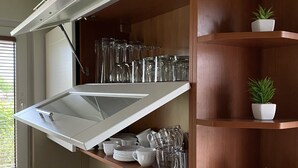 A kitchen with a built-in shelf unit containing glassware and potted plants. - Nice place to stay near Pszczyna (Goczalkowice Zdroj)
