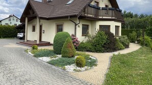 A two-story house with a sloped roof, a balcony, and a driveway leading to the entrance. - Nice place to stay near Pszczyna (Goczalkowice Zdroj)