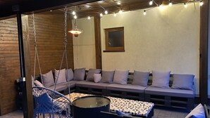 A cozy outdoor seating area with a swing chair, a sofa, and a table. - Nice place to stay near Pszczyna (Goczalkowice Zdroj)