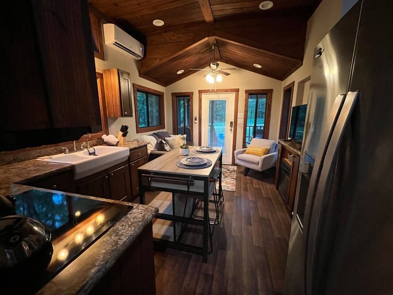 A modern kitchen with a central island, built-in appliances, and a dining area with a view.