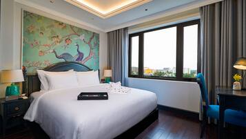 Una habitación de hotel con una cama grande, vistas a la ciudad y un mural en la pared.