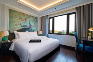 Una habitación de hotel con una cama grande, vistas a la ciudad y un mural en la pared.