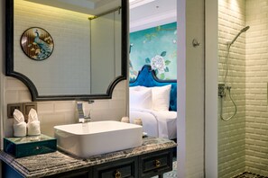 A bathroom with a white sink, dark marble vanity, and a large mirror.