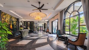 A spacious lobby with a high ceiling, a central chandelier, and a seating area with chairs and a round table. - Hoi An Delicacy Hotel & Spa (Da Nang)