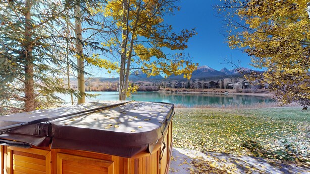 Un bain à remous situé dans un cadre naturel, avec vue sur un lac et des montagnes.