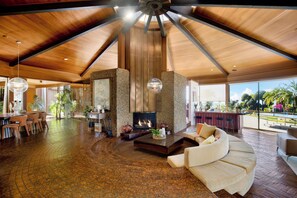A spacious living area with a fireplace, seating, and a view of the outdoors.