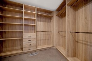 A wooden closet with multiple shelves and drawers.