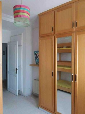 A spacious room with a wardrobe and a lamp.