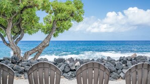 Una spiaggia con sedie e un albero, con vista sull'oceano.
