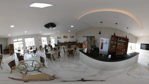 A spacious hotel lobby with a curved reception desk, multiple seating areas, and a large open space with natural lighting. - Hotel Imperio (Aparecida do Taboado)