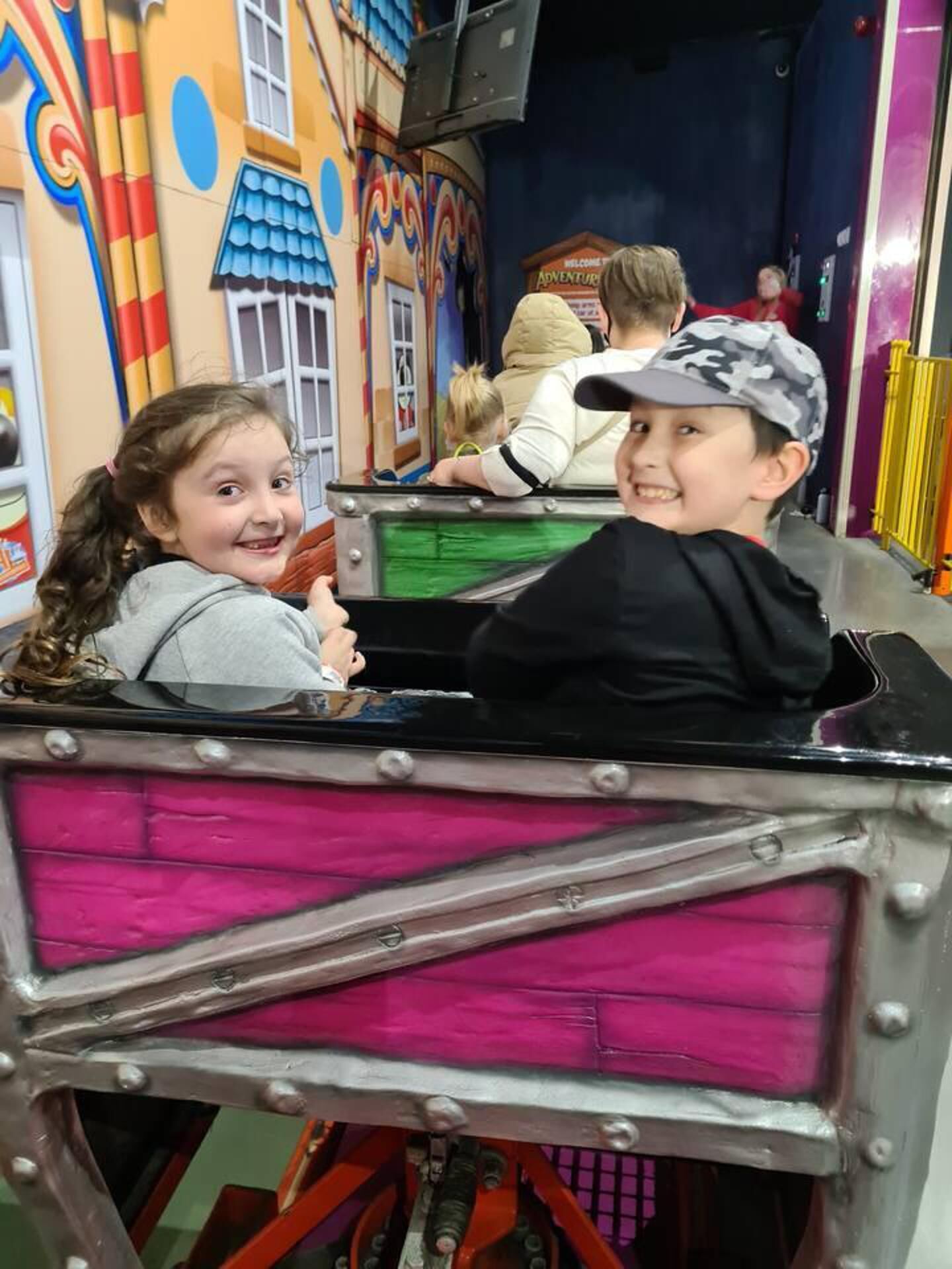 A roller coaster with a pink and silver design, featuring a track and support structure.