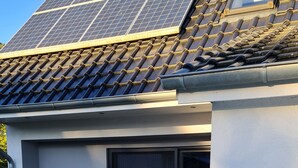 A hot tub with a tiled roof and solar panels above.