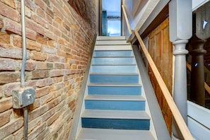 Stairway with a brick wall and a traditional wooden door.