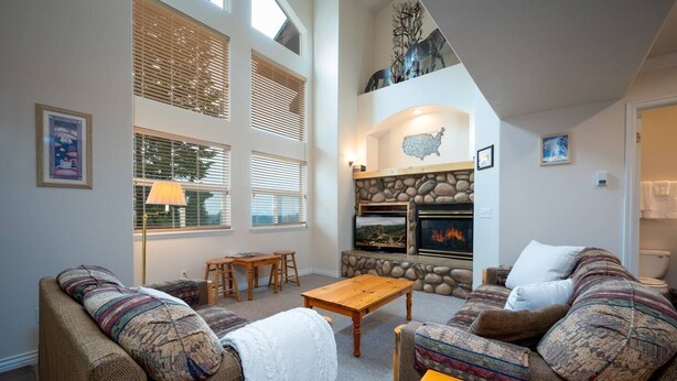 Una sala de estar acogedora con dos sofás, una mesa de centro y una chimenea.