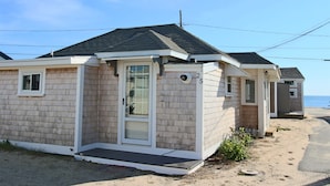 A beachfront mobile home with a small porch and a door.