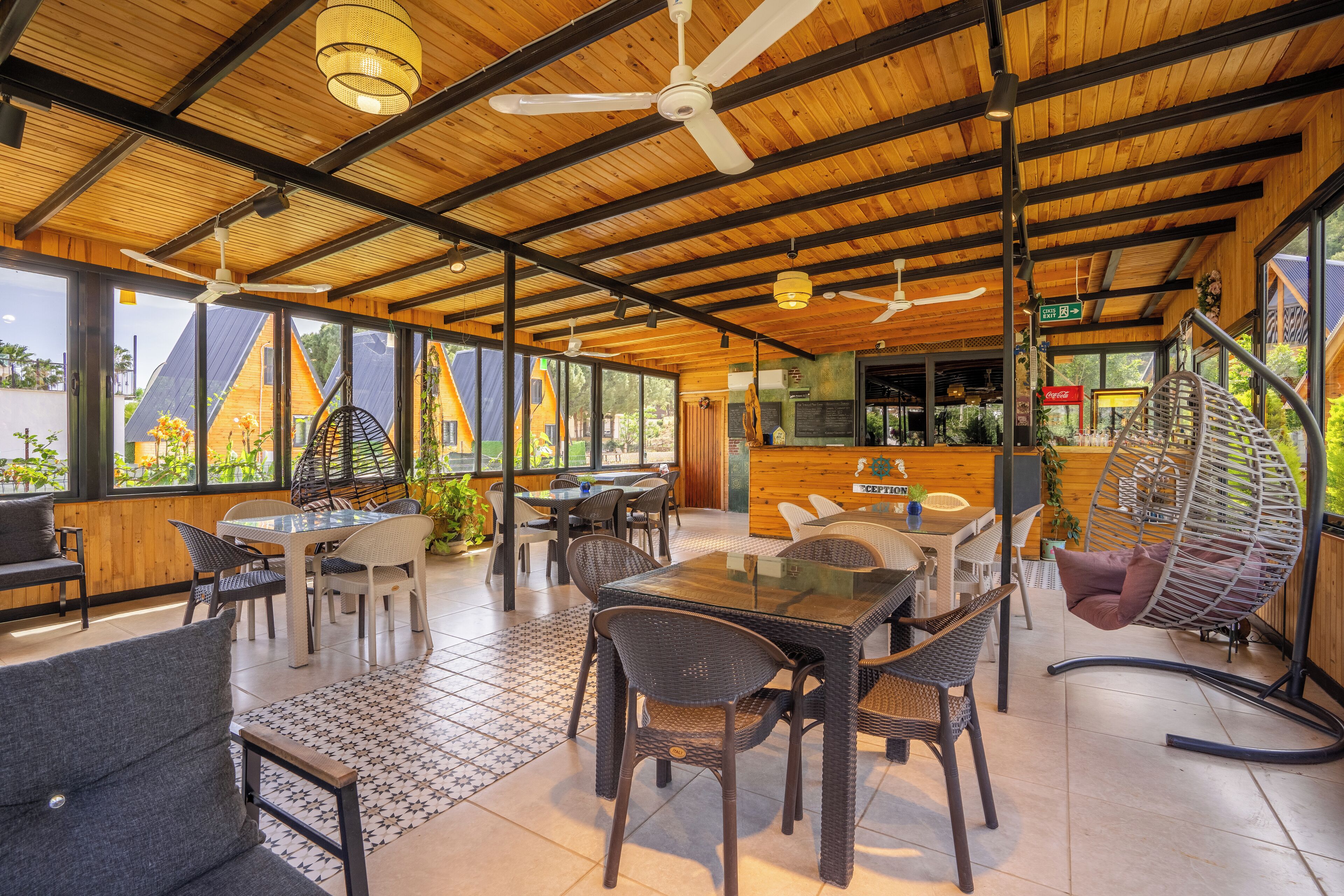 Un restaurant moderne avec des plafonds en bois, de grandes fenêtres et une terrasse.