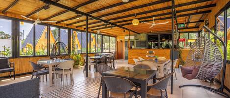 Un restaurant moderne avec des plafonds en bois, de grandes fenêtres et une terrasse.